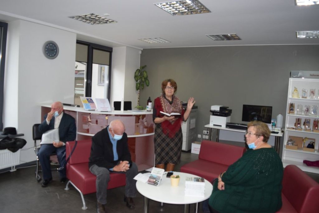 Lektorė stovinti ir laikanti atverstą knygą