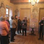 Videniškių vienuolyno muziejuje sustoje žmonės klausosi gidės pasakojimo