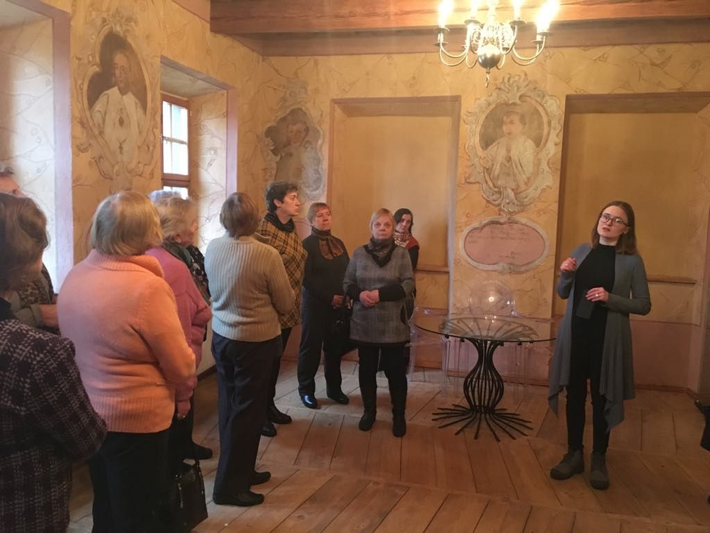 Videniškių vienuolyno muziejuje sustoje žmonės klausosi gidės pasakojimo