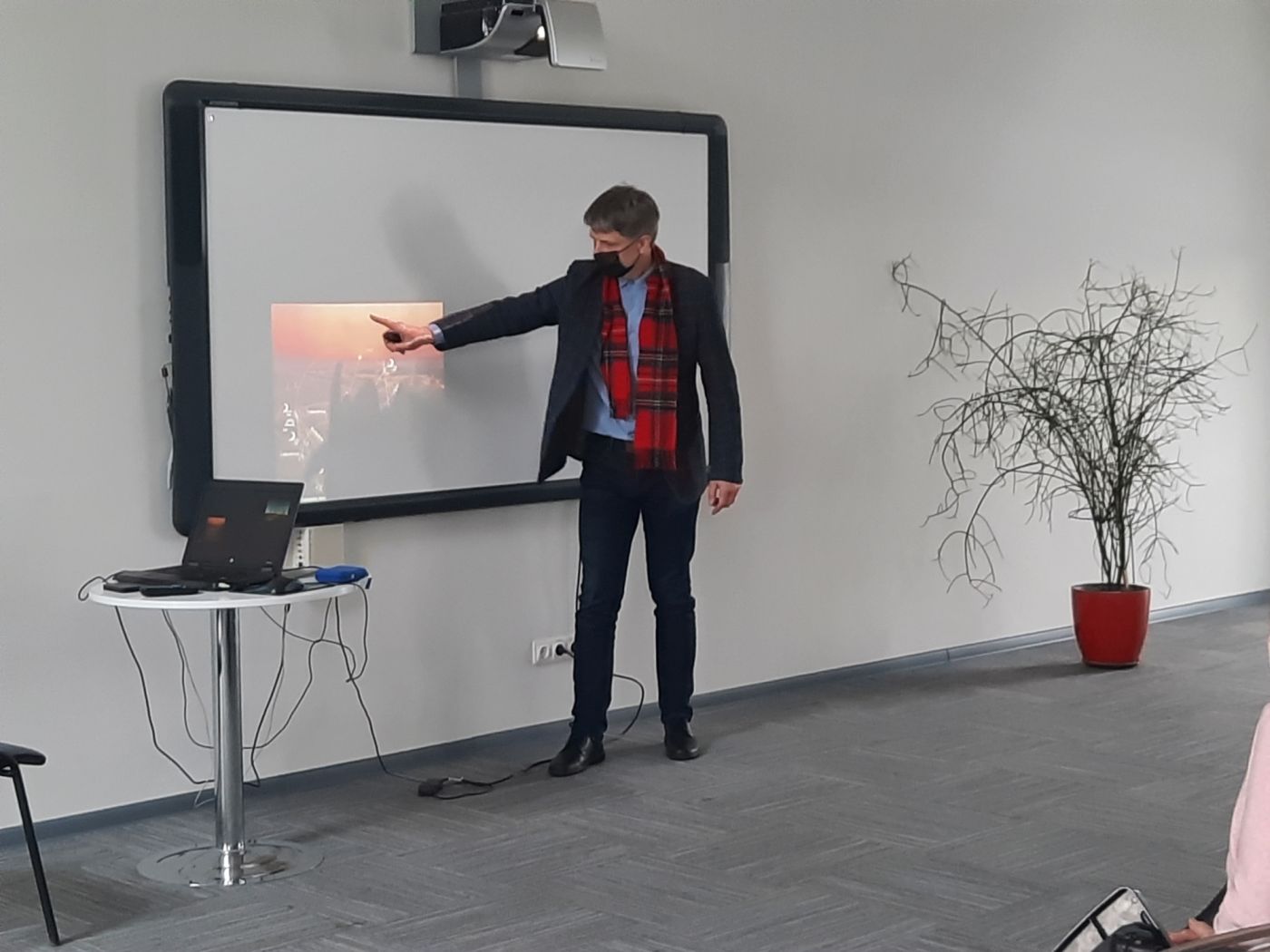 Lektorius, ranka rodantis į nuotrauką ekrane