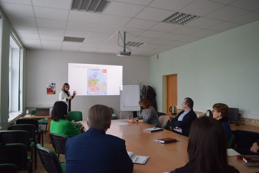 Renginio dalyviai, susėdę klausosi lektorės