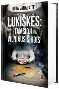 tamsioje kalėjimo kameroje sėdi žmogus už stalo