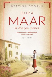moteris stovi prie namo, šalia žydi gėlės
