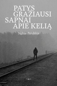 vyras eina geležinkelio bėgiais