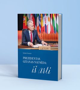prezidentas sėdi ir sako kalbą į mikrofoną