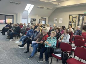 Renginio dalyviai, sėdintys salėje