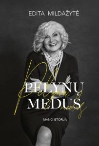 sėdi moteris ir šypsosi